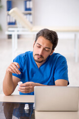 Young male doctor suffering in the clinic