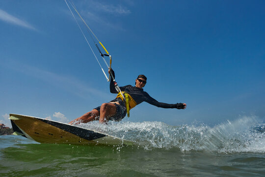 Kite surfer jumps with kiteboard in transition