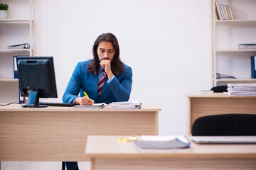 Young male employee working at workplace