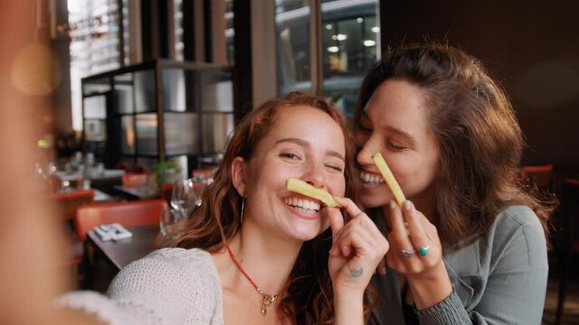 Slow motion of women messing about in restaurant