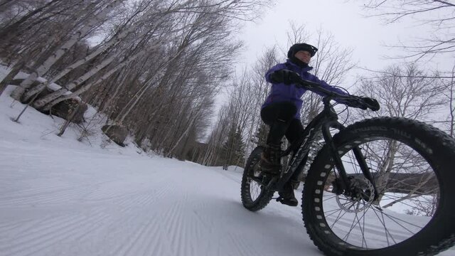 Fat bike in winter. Woman Fat biker riding bicycle in the snow in winter forest. Woman living healthy outdoor active lifestyle