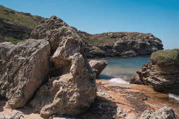 the concept of boating, recreation, travel - splashes of blue water in the rsea, ocean, mountains, sky, stone shore. Copy space