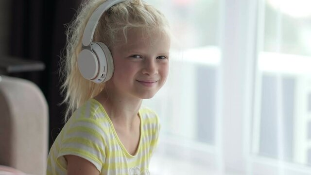 Portrait beautiful smiling girl in headphones. child listening enjoying music. rest, relaxation, quiet time for yourself at home.