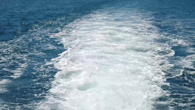 Water foam trace behind sailing ship. Fast moving motor boat in sea, view of yacht trail behind. Rear view of motor speed boat with Water wake foam trace behind the engine. 4 k video