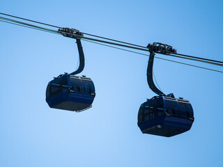 two dark blue funiculars on a blue sky background