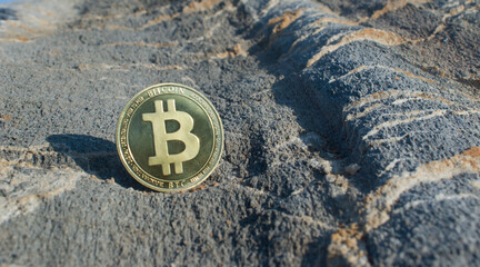Bitcoin coin, on natural stone background with BTC Cryptocurrency coins investment concept and text design.