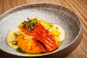Grilled salmon steak with vegetables puree and fish sauce with pumpkin and spices.