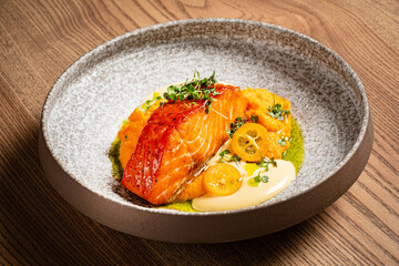 Grilled salmon steak with vegetables puree and fish sauce with pumpkin and spices.