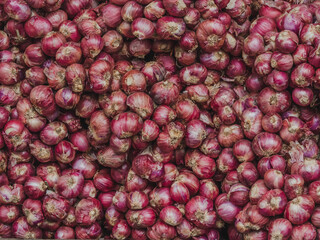Fresh small red onion on shelves at supermarket.