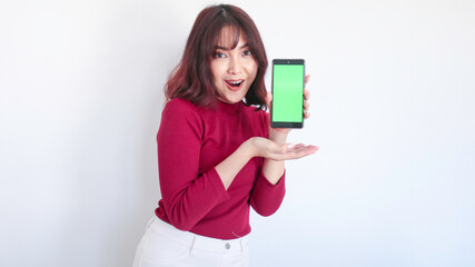 Shock Asian beautiful girl point on green screen phone in white background