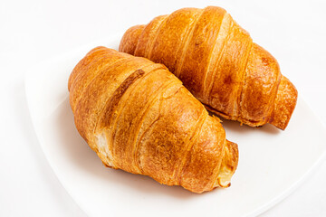 Fresh tasty croissants on white background.