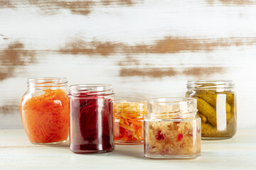 Fototapeta na wymiar Fermented food. Canned vegetables. Pickles, sour cabbage and other organic preserves in mason jars. Healthy vegan cooking background with copy space
