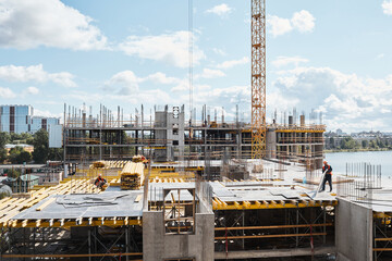 Wide angle view at construction site with unfinished residential buildings against blue sky, copy...