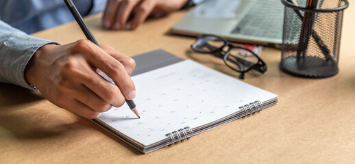 Businessman agenda calendar and reminder agenda work online at home men plan daily appointments and vacation travel journals in a diary at their desk . calendar reminder event concept .