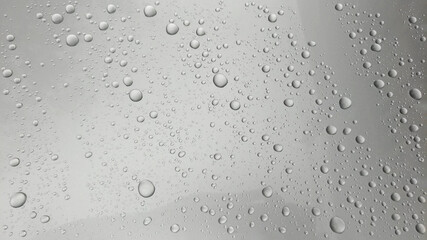 Close-up of water droplets on silver glass.