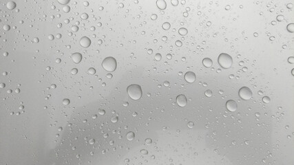 Close-up of water droplets on silver glass.