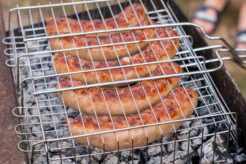 pork sausages fried on coals on the grill