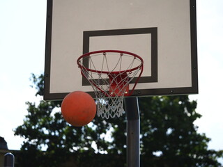 ball flies into the basketball hoop on the street during the game