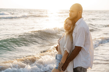 Young happy couple on seashore enjoying the sea