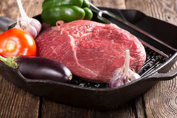 Raw meat and vegetables are prepared for grilling