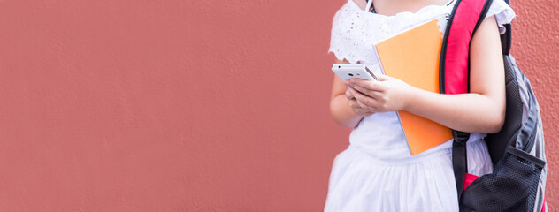 girl with backpack using mobile phone with copy space