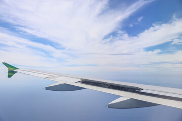 Obraz premium Wing of an airplane with beautiful sky cloud