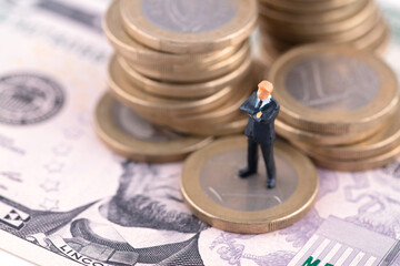 Miniature businessman doll on euro coin