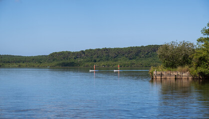 Dos personas haciendo paddle sup en un lago de Francia.