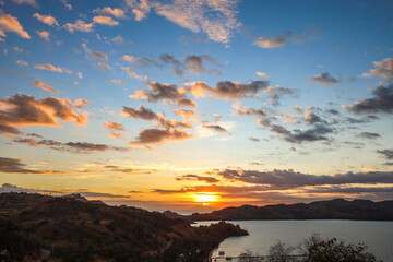Dramatic sunset sky over the sea with hills