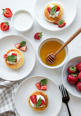 Cottage cheese pancakes, ricotta fritters on ceramic plate with  fresh strawberry.