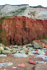 Hunstanton Cliff Erosion, these sea facing rocks reveal rare red chalk & prehistoric rocks at this historic seaside resort. along the Norfolk coast with a few flakes of snow on a fresh winters day.