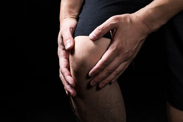 膝を押さえる男性の手