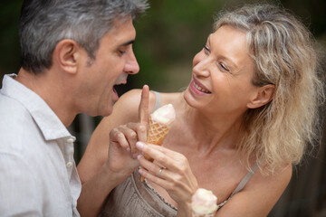 happy mature attractive middle-aged couple eating ice cream