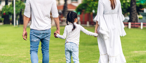 Portrait of enjoy happy love asian family father and mother holding little asian daughter girl hand in moments good time in summer park at home