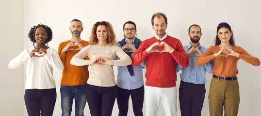 Studio group portrait of thankful youth and senior citizens sending you love, support and gratitude. Team of young and mature people doing heart shape hand gesture isolated on white banner background - obrazy, fototapety, plakaty