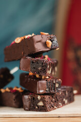many delicious chocolate brownies with nuts in chocolate on a stick in the summer in a cafe