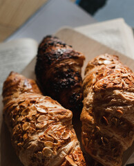 French croissants in a summer cafe on a wooden tray next to books