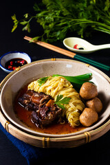 Asian Food Concept Chinese Egg noodle pork and meatball soup on black background with copy space
