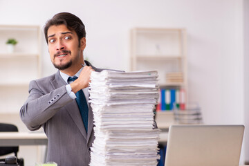 Naklejka premium Young male employee unhappy with excessive work in the office