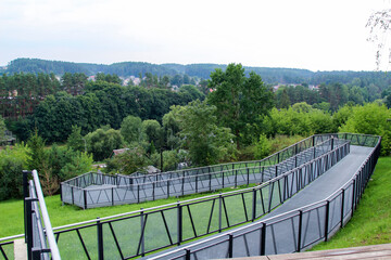 Fototapeta na wymiar Pedestrian terrace, ramp - descent from the hill to the river. Metal structure on the hill.