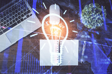 Bulb drawing over computer on the desktop background. Top view. Double exposure. Idea concept.