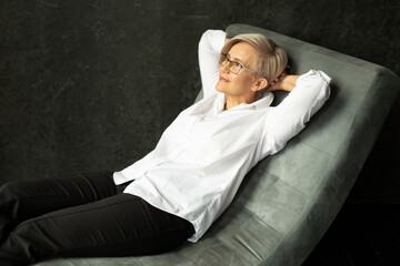 Obraz premium comfortable rest in a chair lying on the sofa of a stylish woman of the age 