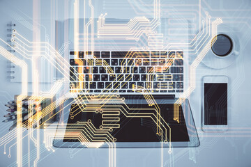Technology hologram drawing over computer on the desktop background. Top view. Double exposure. Tech concept.