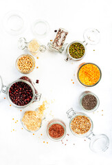 Grocery, home stocks in plastic free storage and jars. Various beans, grains, cereals, legumes, seeds in reusable cans. White table. Zero waste and sustainable llifestyle