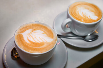 Two cups of coffee. Latte with a pattern in white cups.
