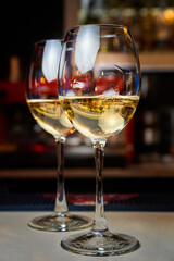 Two glasses of white wine on the bar. Close-up, selective focus
