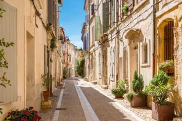 Selbstklebende Fototapete Enge Gasse View of an idyllic street with green plants in Arles. 
