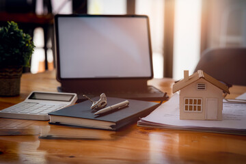 Naklejka premium Close up house model over the Sale representative offer the price list and condition for purchase or rental on the working space table in new place,sign contract Moving and House Hunting concept.