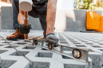 Making of floor. Young man working in uniform at construction at daytime