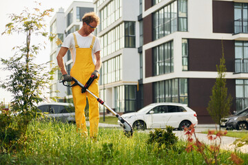 One person. Man cut the grass with lawn mover outdoors in the yard